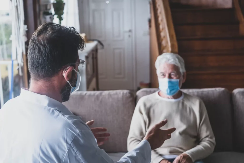 a man wearing a mask talking to a woman