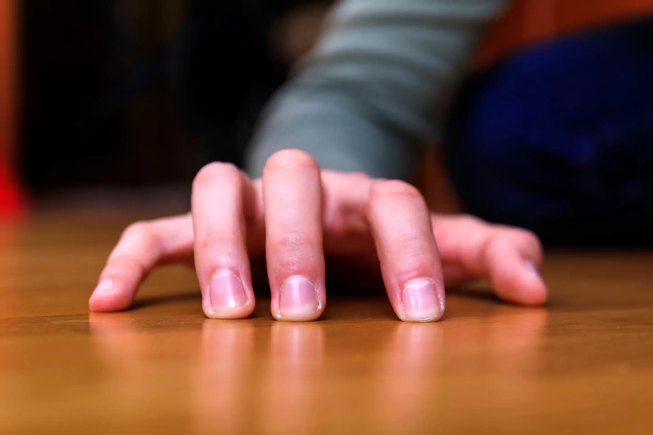 a hand on a wood surface