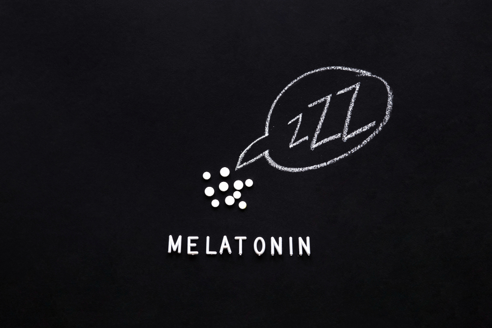 Flat lay composition of melatonin supplements with chalkboard diagram