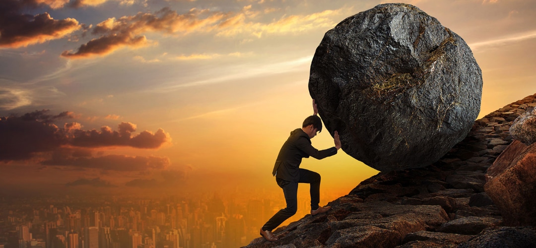 man demonstrating hard work by rolling a boulder up a mountain man demonstrating hard work by rolling a boulder up a mountain